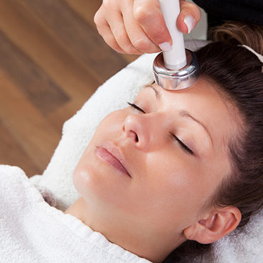 Young woman receiving laser therapy.