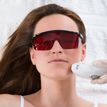Young Woman Receiving Epilation Laser Treatment On Face At Beauty Center